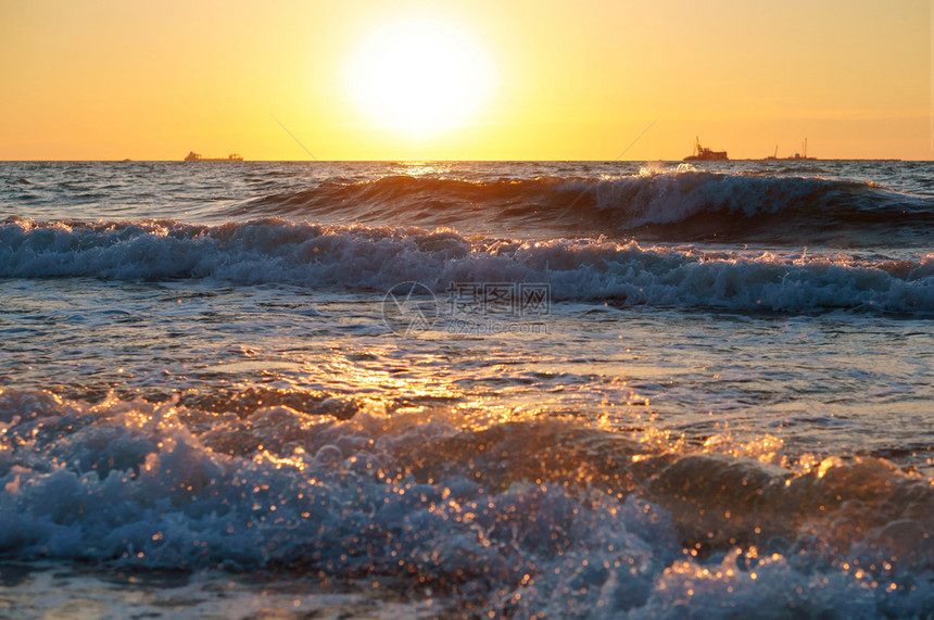 海滩上日落浪中的出上落浪漫风景图片