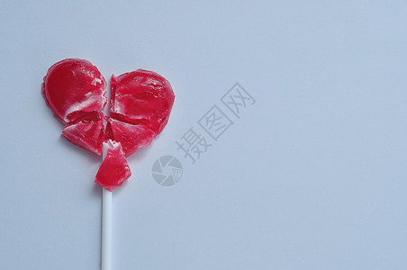 悲伤痛一个破碎的红心棒糖象征着一颗破碎的心糖果背景
