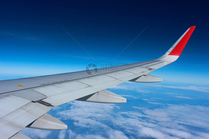技术翅膀云蓝天空上方的飞机翼从窗口看超过图片