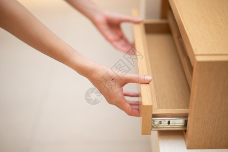 抓住贮存壁橱妇女手拉开抽屉的木制柜子图片