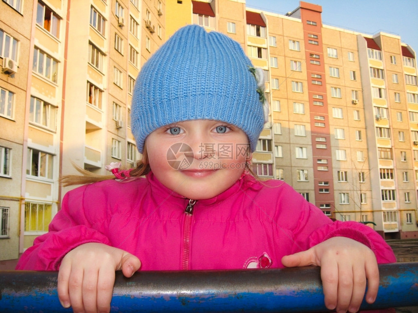 蓝眼女孩在一间多层房屋背景的横条上被一个蓝色眼睛的女孩子童年父母图片