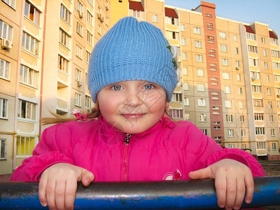 蓝眼女孩在一间多层房屋背景的横条上被一个蓝色眼睛的女孩子童年父母图片