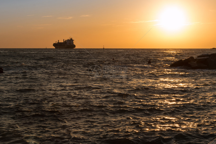 沿海日落时在乔ppy海的货船轮票礁地中海图片
