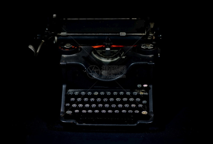 黑色背景的古老旧打字机卷手指母图片