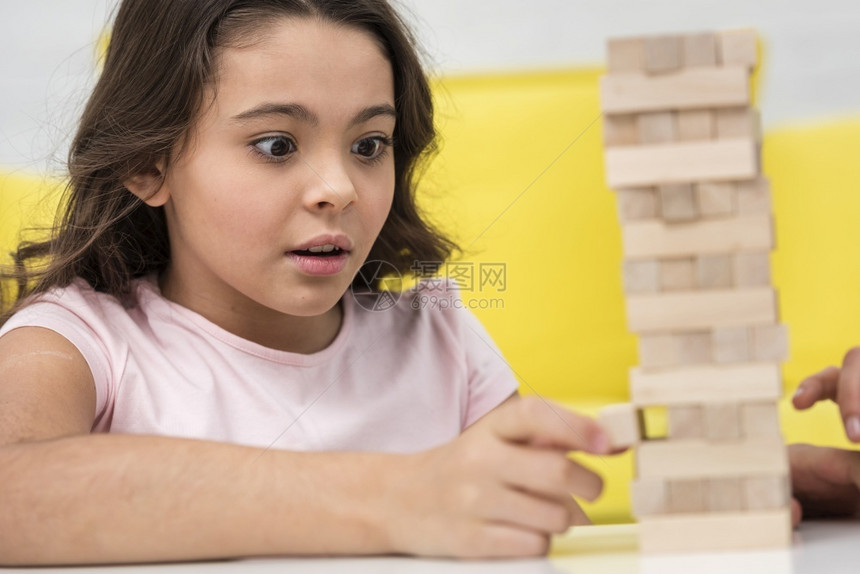 得到人们小女孩在玩木塔游戏的同时要照顾好自己的小女儿花朵图片