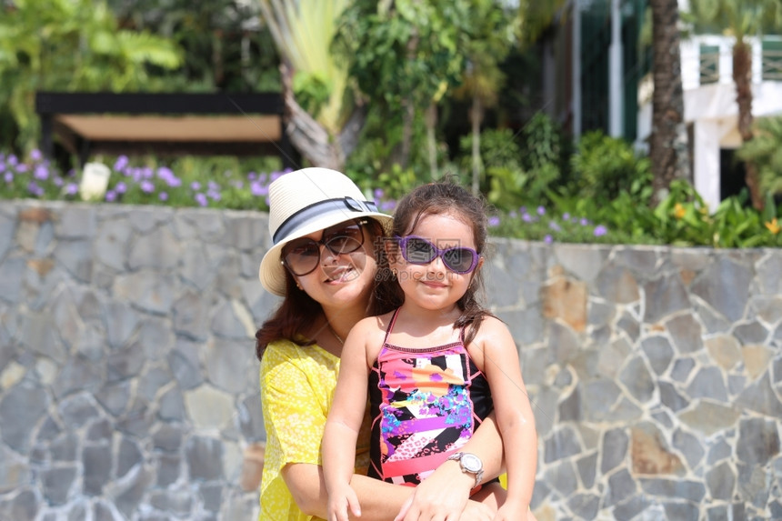 水平的父母亲和女儿享受暑假户外活动带着美丽的太阳眼镜在小女孩身上专注快乐的图片