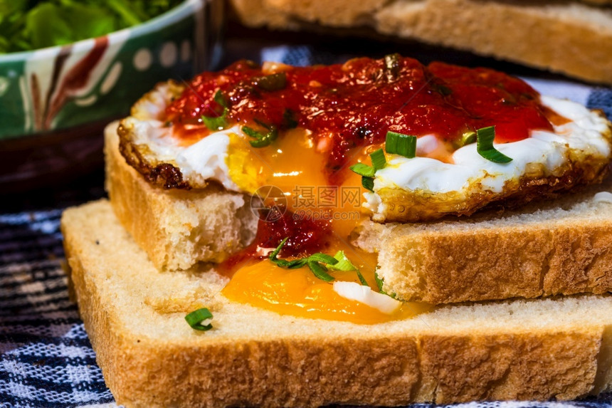美食用番茄酱和大蒜在烤面包上分离的煎蛋特写黄一顿饭图片