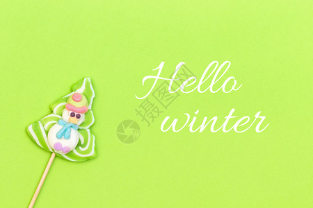 绿色的棒棒糖冬季和糖果棒滑稽雪人圣诞树在绿色背景的一棵树顶端风景贺卡片冬天你好寒和糖果棒有趣的雪人孩子们躺着新的设计图片