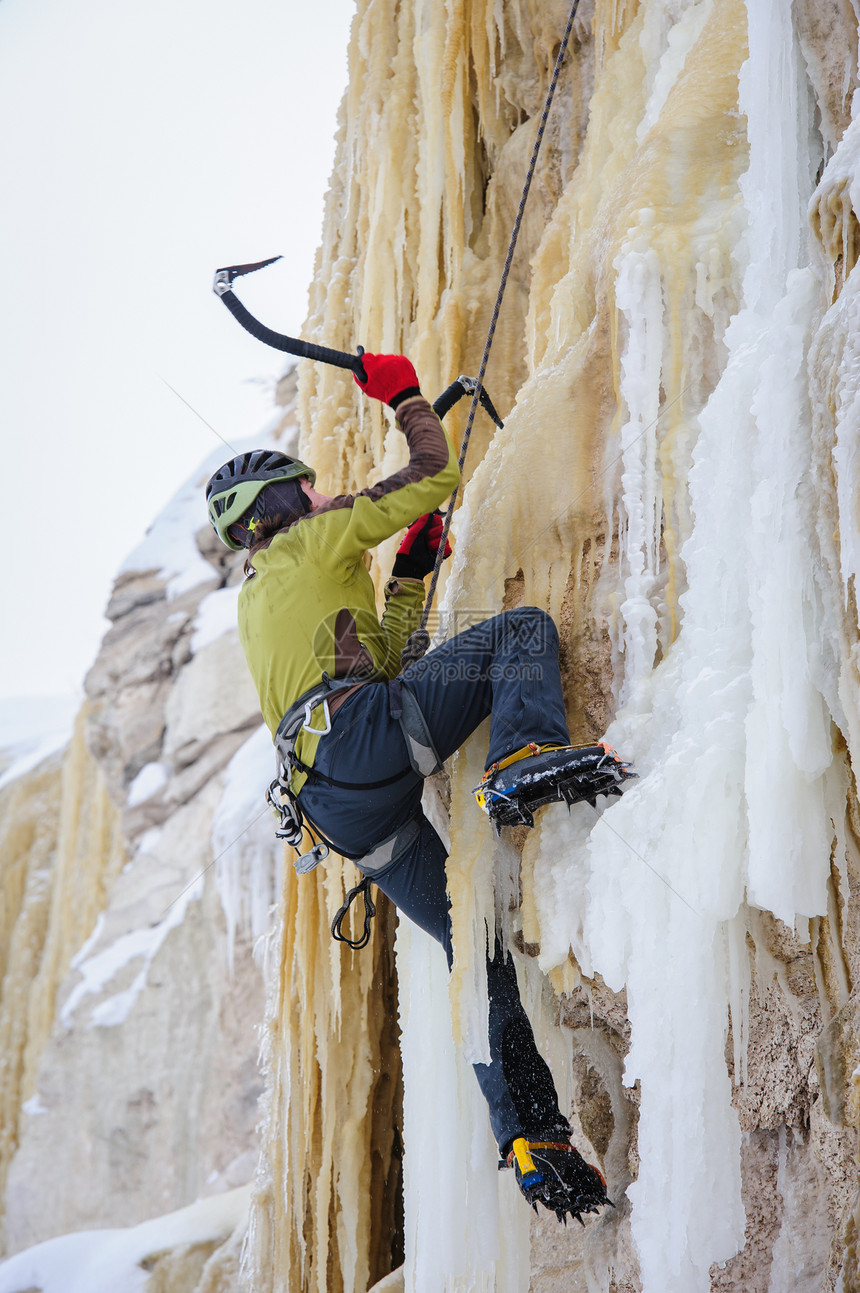 攀登年轻人用冰斧在上爬爪冒险图片