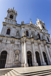 雕像18世纪末在葡萄牙里斯本建造的已故巴罗克和新立国皇家巴西利卡以及最神圣之心修道院的面纱新古典主义塔背景图片