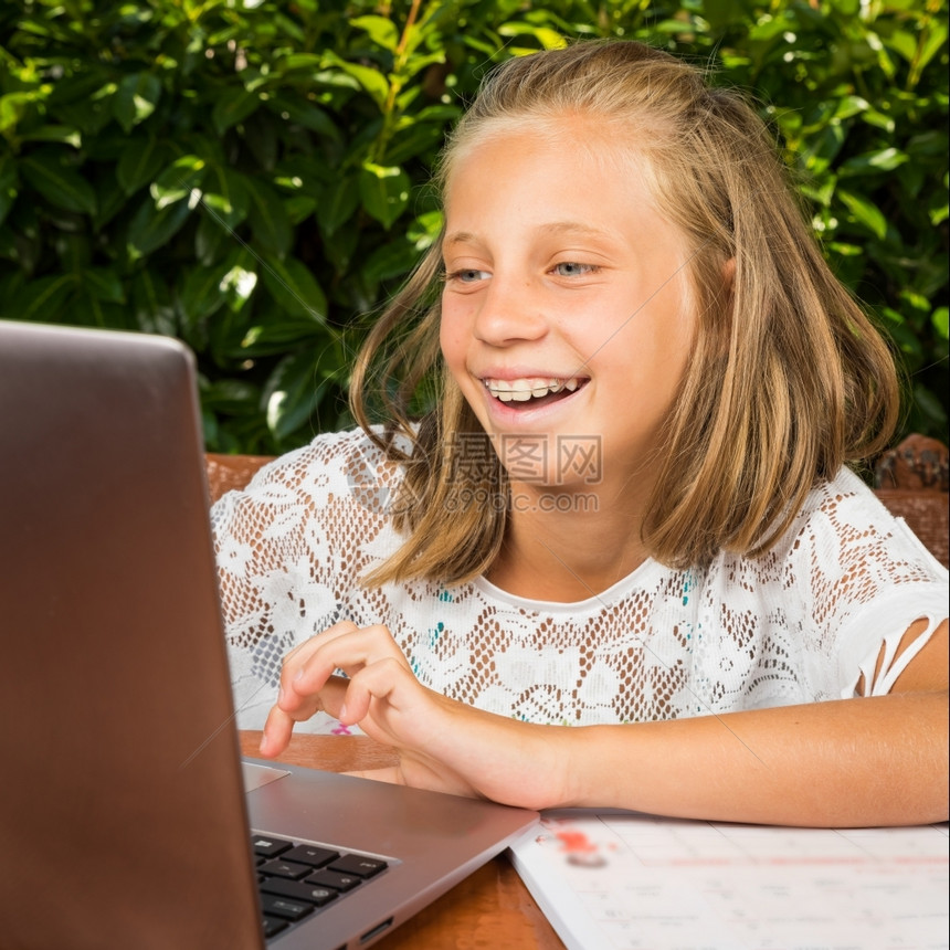 女孩蓝色的10岁美少女学生在电脑屏幕上有好消息Y我人们图片