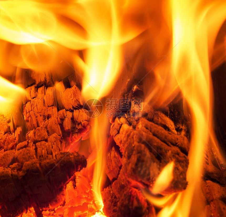 火焰在壁炉里烧和柴紧贴在壁炉里烧柴的镜头附近黑暗的荒野图片