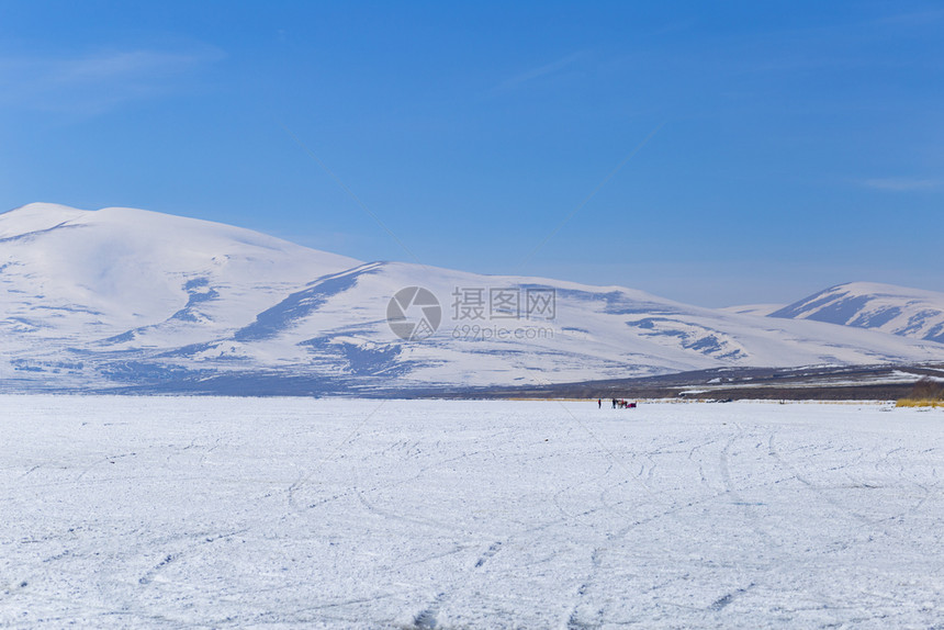 下雪的海冰冻湖泊和山上风景在雪中天图片