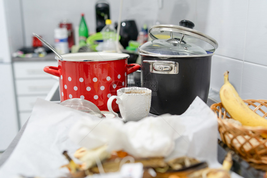 洗碗白色厨房的侧边视图在烹饪后一团乱糟的柜台用具和厨房电器上配有未洗过的脏锅和盘子一种花盆图片