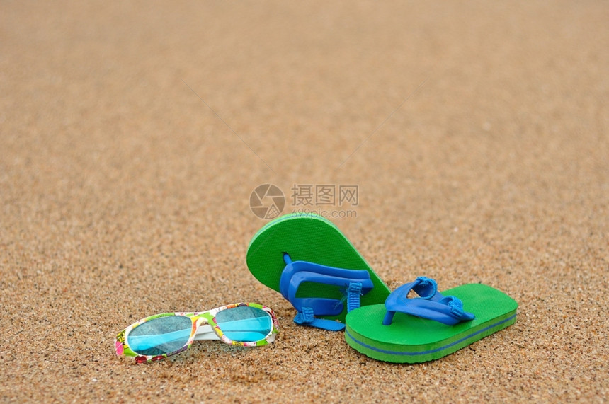 穿夏令一对绿色和蓝的飞轮海滩上有彩色墨镜配饰图片