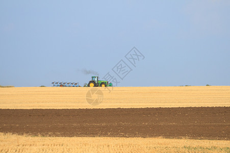 乡村的拖拉机在田里耕种土地准备农田图片