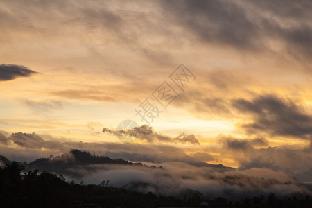 早晨和太阳之间有雾笼罩山岳冬天景观覆盖图片