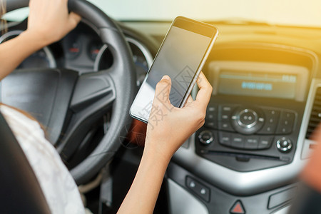 女孩车辆亚裔妇在路上驾驶汽车使用智能手机在路上电话屏幕高清图片素材
