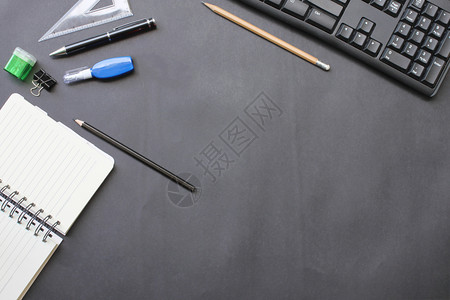 顶端笔记本和铅键盘上面的记本和铅键盘上装有附件放在办公室的黑桌子上在工作中复制办公空间概念蜡笔灰色的基普背景图片