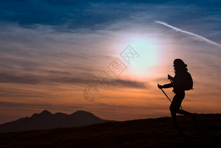 孤独运动快乐的妇女在日落外出探险活跃生方式山丘上徒步旅行图片