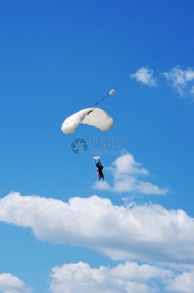 蓝色的伞兵和白降落伞上的天空潜水器自由泳图片