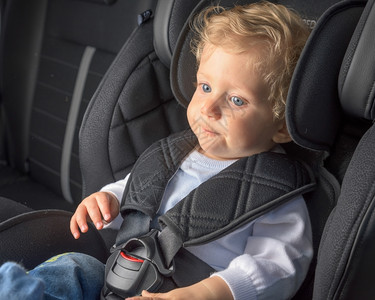 美丽的可爱男孩8个月大坐在安全汽车座椅上老的婴儿高清图片素材