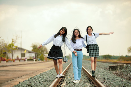 旅行三名亚裔青少年在铁路赛道上玩乐美丽旅游图片