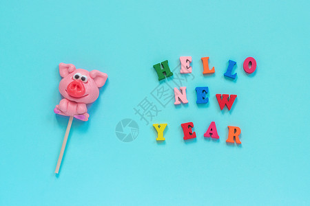 猪你好运立体字希望躺着有趣的粉红猪棒糖和多彩标志你好新年在蓝底背景的色新年风景最上观菜样贺卡猪棒冰蜜年短信新快乐粉色的背景
