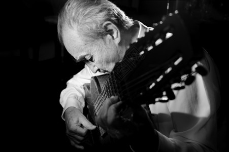 爵士乐浓度巴斯塔一个穿白衬衫的老人弹着声音吉他黑暗背景单色图片