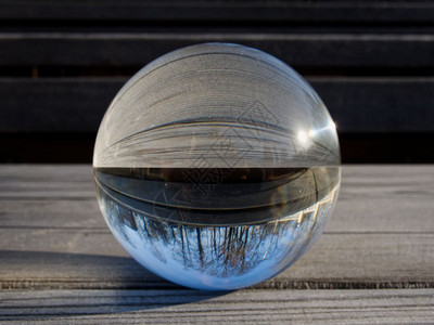 反射光滑里面背景和纹理木制桌上的玻璃球折射内风景的一部分玻璃球折射图片