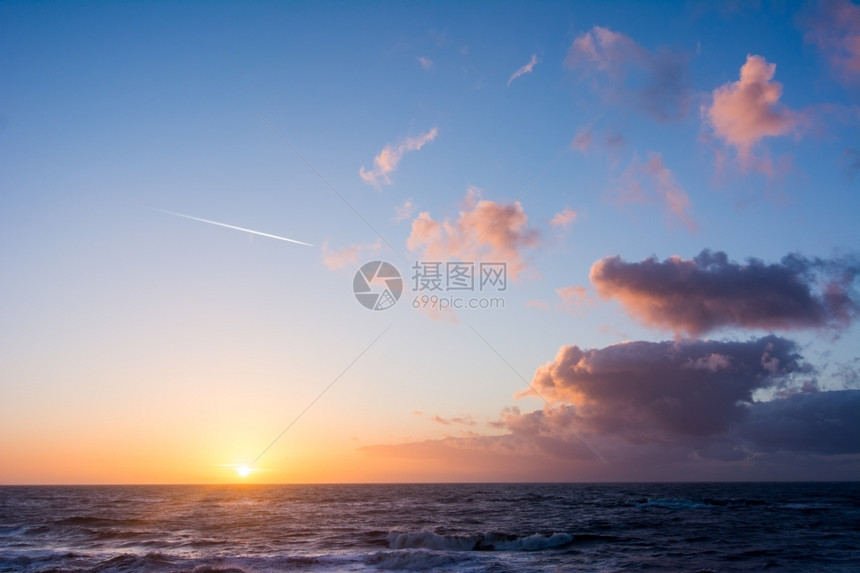 达屈海面上空的日落和云风海浪景地平线图片