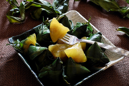 双倍的文化五月日越南传统食物双五节或Tetdoanngo绿叶上粘糊的米糕也称为金字塔形状的banhuTro焦图片