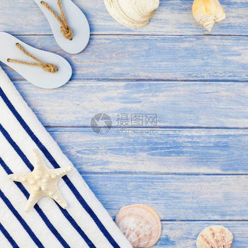 海滩白色的毛巾翻滚贝壳海和星的顶端视图其背景为糊贴蓝木板底盘并附有空间锈式平板框架模文本复制件旅行图片