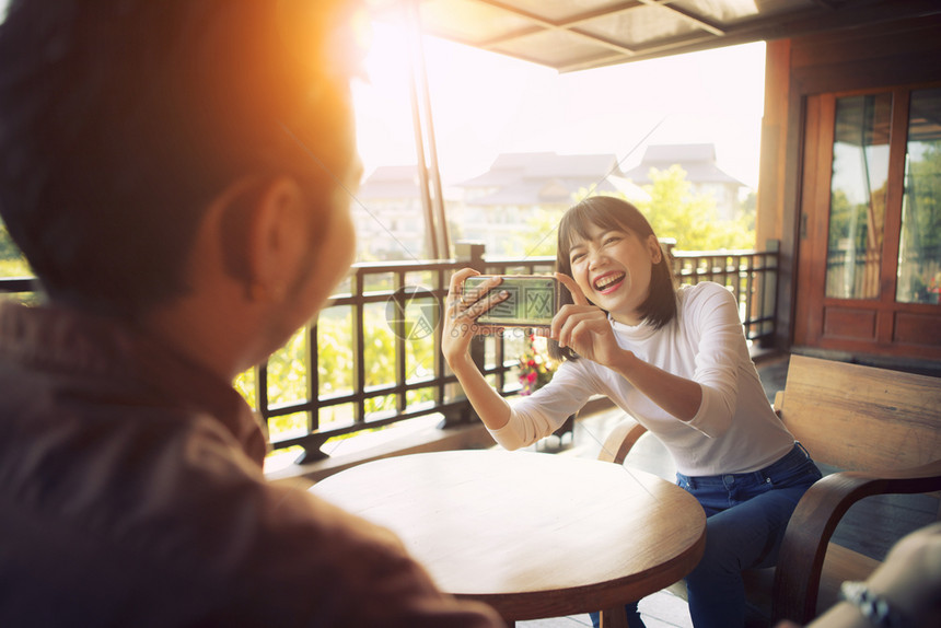 现代的美丽快乐年轻女用智能手机拍照充满了幸福感的情欲经过愉快图片