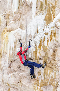 冰爪风险冒年轻人用冰斧在上爬图片