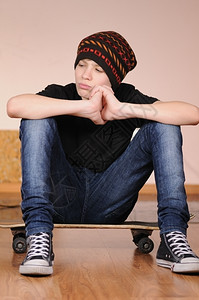 极端溜冰者带着滑板戴帽子的少年人快乐图片