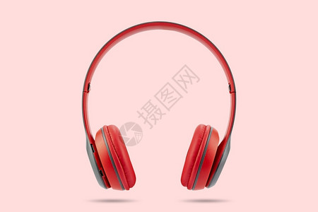 现代设计红色无线耳机在粉色糊面背景上隔离个人的迪斯科立体声图片