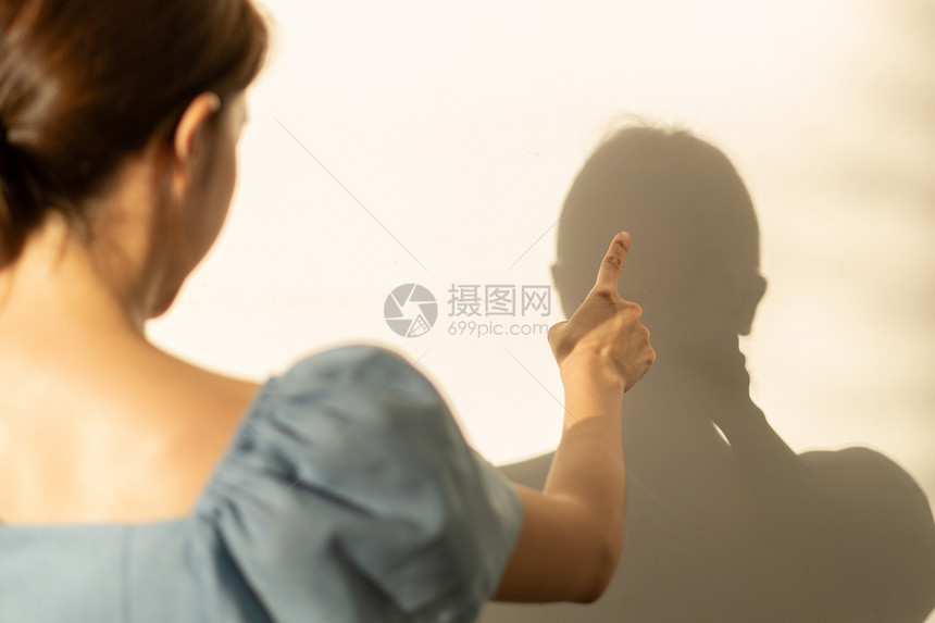 疯狂的挤户外女人疯了在墙上争她的影子图片