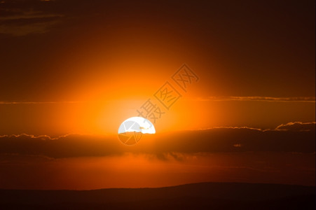 太阳的橙色圆盘日落时沉入地平线自然早晨阳光图片