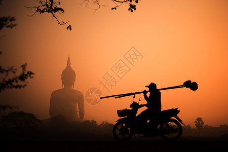 宗教月光大佛日落时有金色的天空人骑摩托车后拿着竹棍的人休旅影佛教精神背景图片