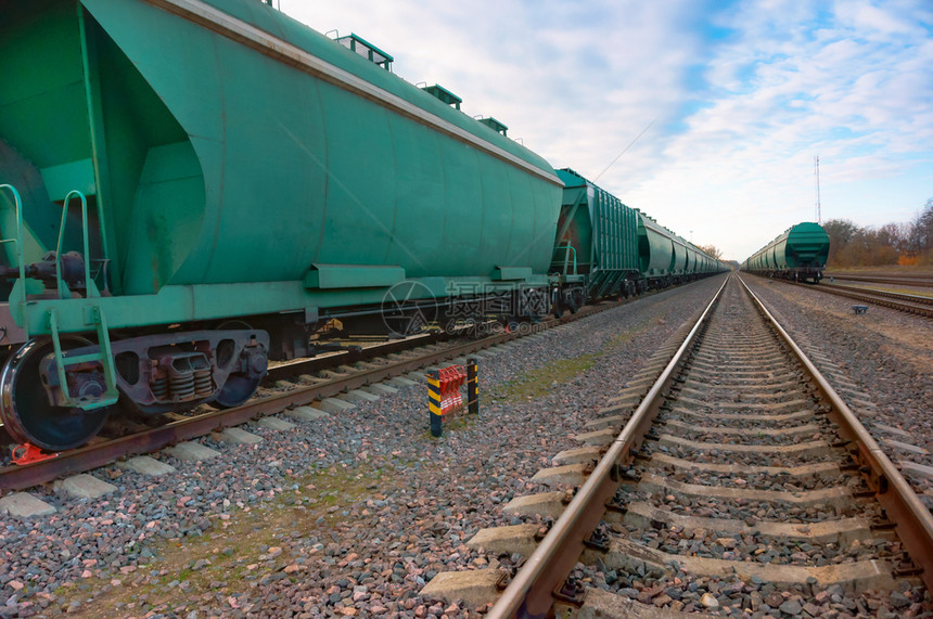 俄罗斯贸易货运列车绿色厢在铁路货运列车绿色的轨道上移动图片