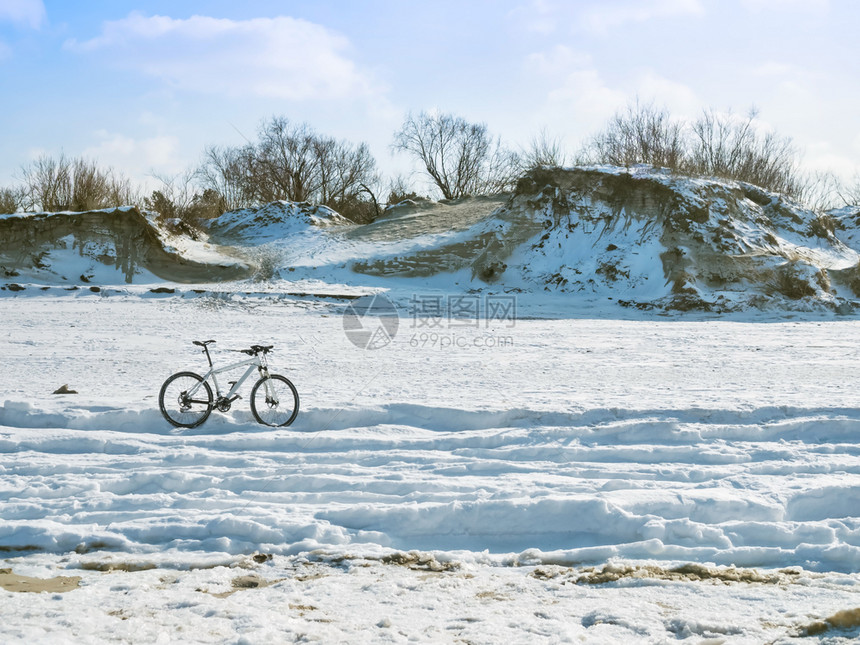 干净的悬崖背景上自行车覆盖着雪陡峭的海岸悬崖背景上的自行车岩石树图片
