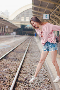 快乐的女孩妇走在铁路上孤独图片