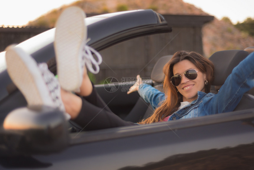 快乐的年轻女士享受她的可兑换车夏天乐趣逃脱图片