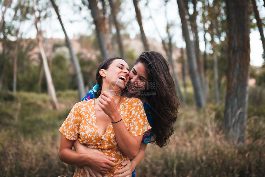 女士两名身穿裙子的年轻妇女在森林中行走微笑夏天图片