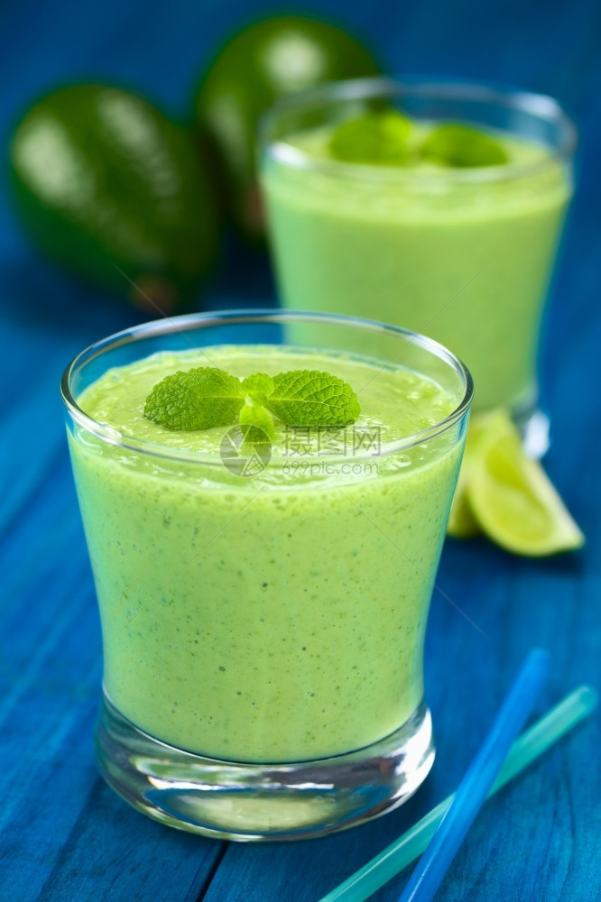 制作由新鲜的avocado石灰和酸奶制成的健康清新绿色冰沙配有薄荷糖在蓝木选择焦点上戴眼镜聚焦于饮料上的大薄荷叶食物泥图片