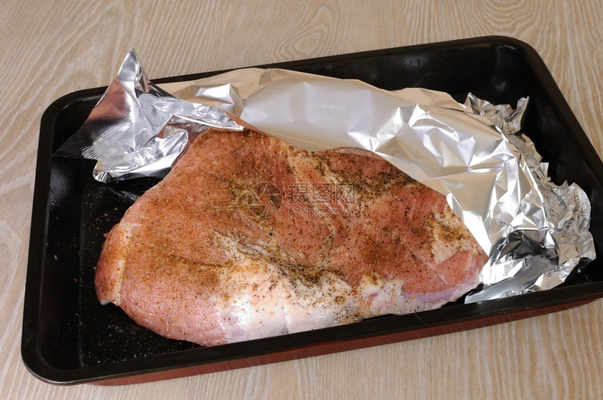 一块生猪肉火腿在粉末下面的烘烤板上优雅蛋白质晚餐图片