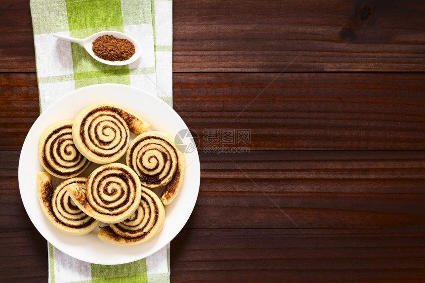 烘烤的由酵果制成装满糖和可粉的自制卷或面包用自然光照在深木头上糕点高架图片