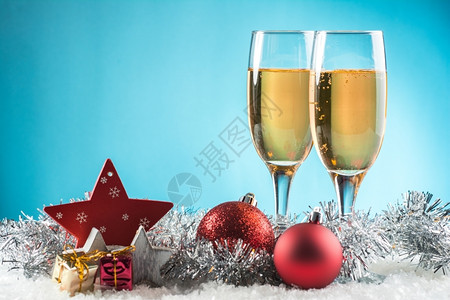 快乐的两杯雪地上香槟准备庆祝圣诞节蓝色背景为了装饰品图片