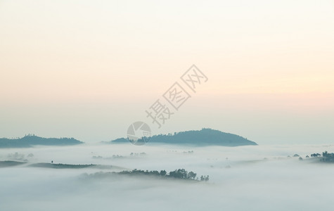 云多雾路段风景寒冷的清晨雾笼罩山岳和树木太阳升起图片